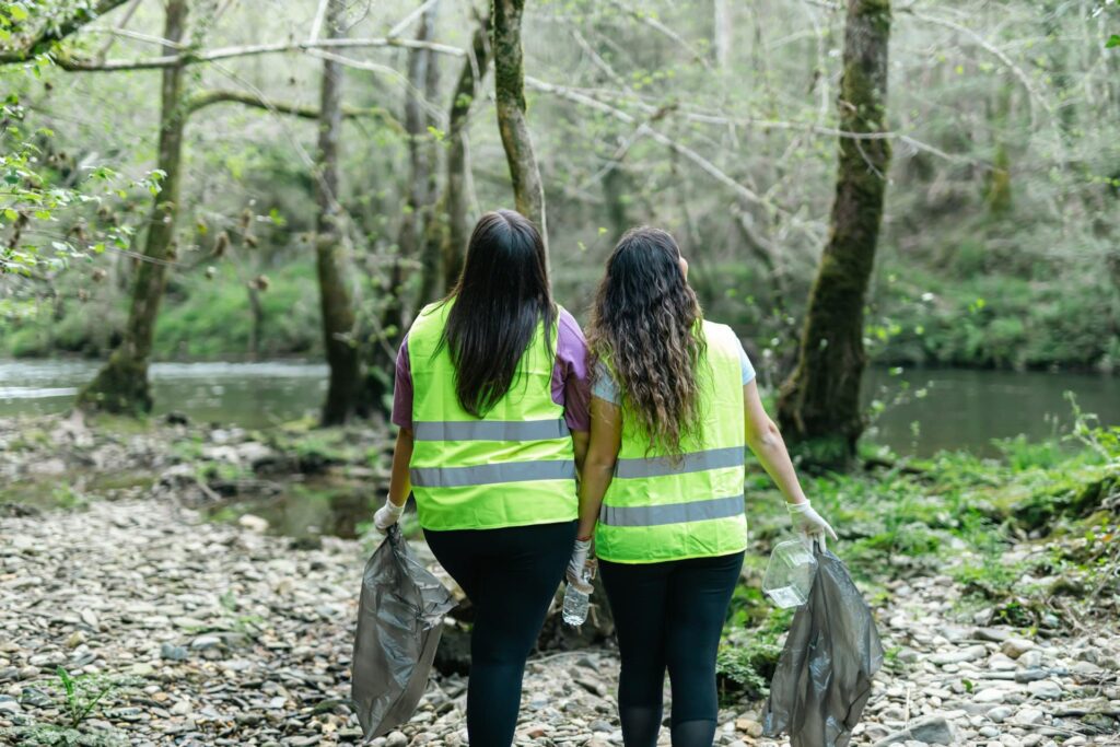Two ladies that are part of an NGO clearing debris in a landfill